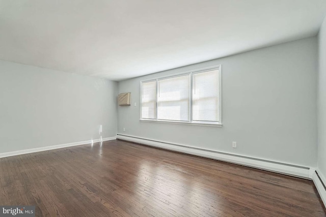 unfurnished room with a wall mounted AC, baseboard heating, and dark hardwood / wood-style floors