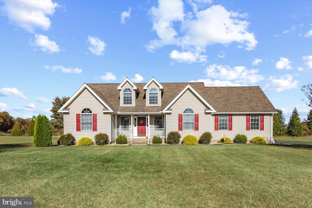 cape cod house with covered porch and a front yard