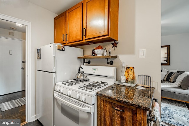 kitchen featuring dark stone countertops and white gas range oven