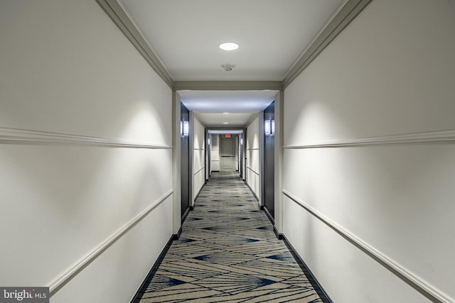 corridor with dark colored carpet and ornamental molding