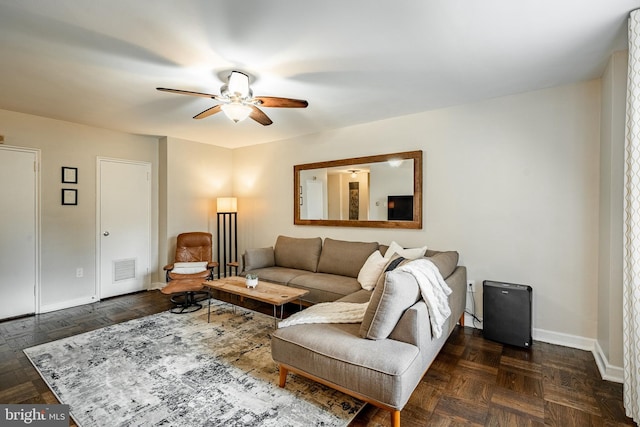 living room featuring ceiling fan and dark parquet floors