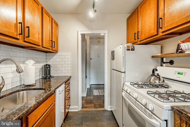 kitchen with dark hardwood / wood-style flooring, dark stone counters, sink, backsplash, and white appliances