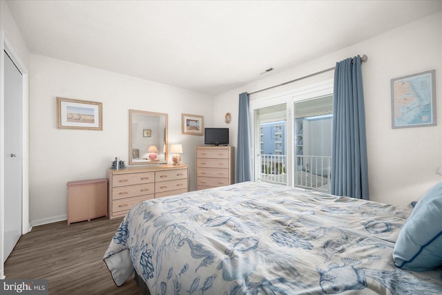 bedroom with dark hardwood / wood-style floors, a closet, and access to outside