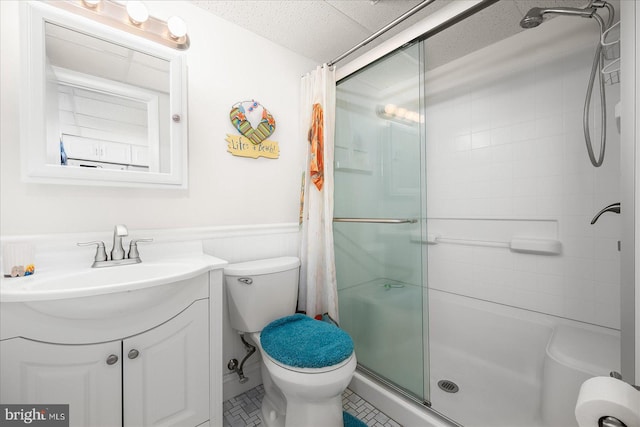 bathroom with walk in shower, a textured ceiling, vanity, tile patterned floors, and toilet