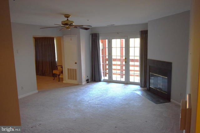 unfurnished living room with visible vents, ceiling fan, carpet flooring, baseboards, and a fireplace with flush hearth