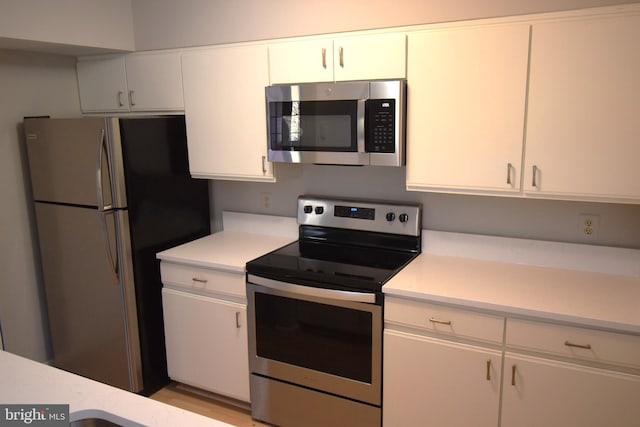 kitchen featuring light countertops, white cabinets, and appliances with stainless steel finishes