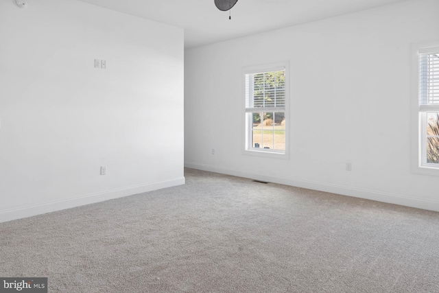 carpeted spare room with ceiling fan