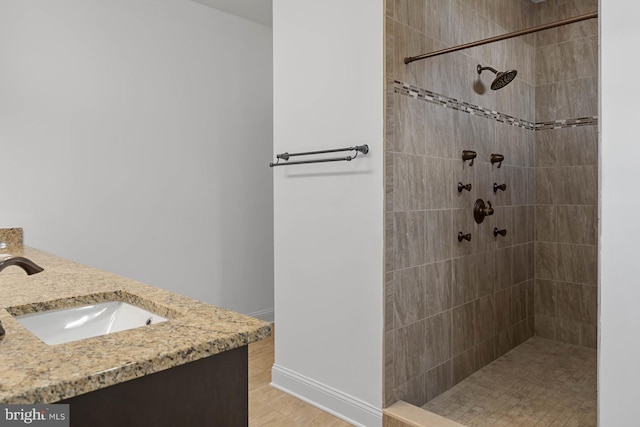 bathroom with vanity, hardwood / wood-style floors, and a tile shower