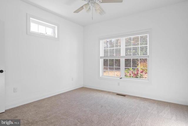 carpeted spare room featuring ceiling fan and a healthy amount of sunlight