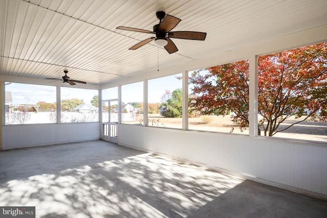 unfurnished sunroom featuring a healthy amount of sunlight and ceiling fan