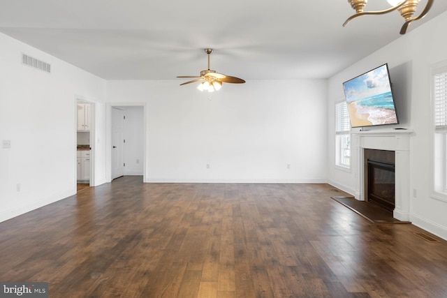 unfurnished living room featuring dark wood-type flooring and ceiling fan