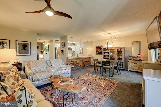 carpeted living room featuring ceiling fan with notable chandelier