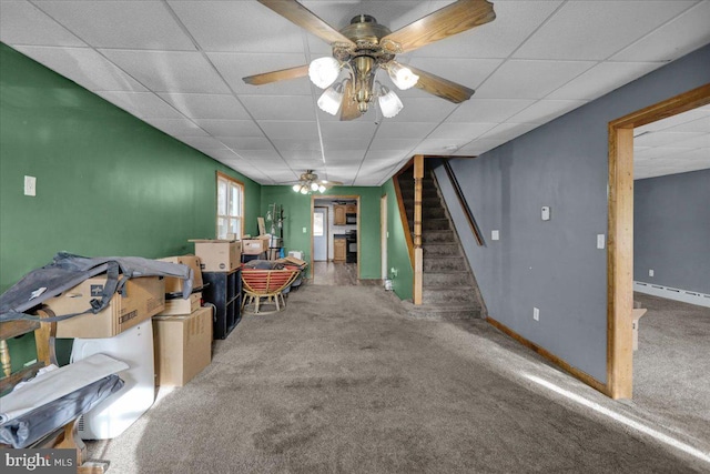 interior space with baseboard heating, a drop ceiling, and carpet flooring