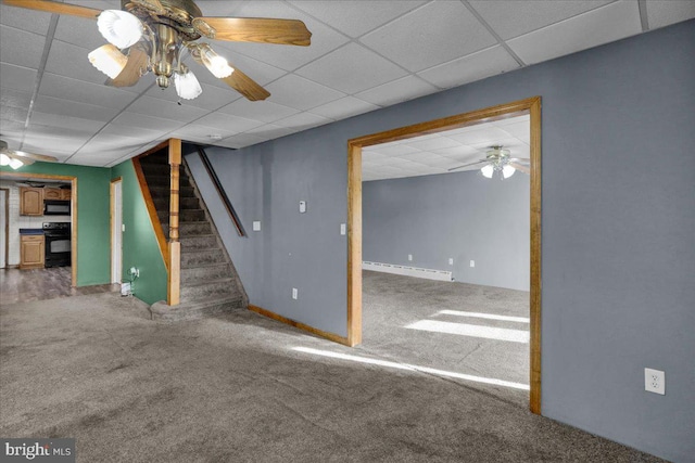 unfurnished living room with a drop ceiling, a baseboard heating unit, carpet flooring, and ceiling fan