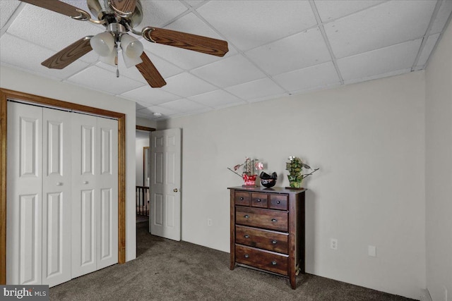 carpeted bedroom featuring a closet, ceiling fan, and a paneled ceiling