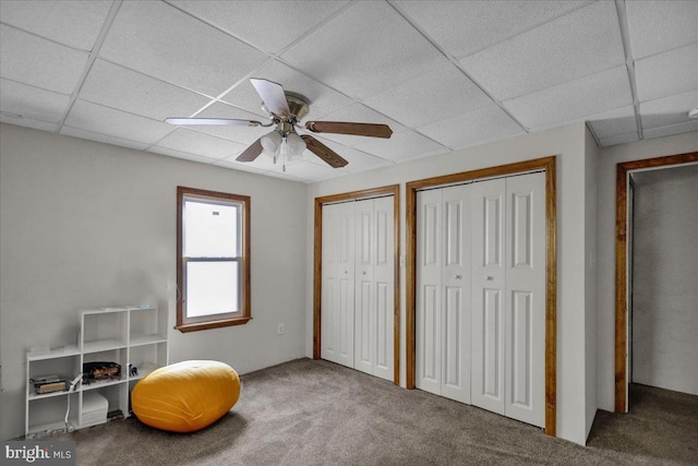 living area featuring carpet floors, a paneled ceiling, and ceiling fan