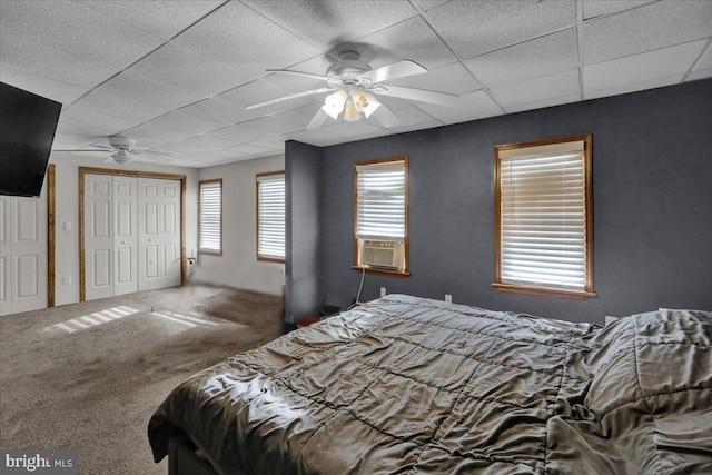 bedroom with cooling unit, carpet floors, a closet, ceiling fan, and a paneled ceiling