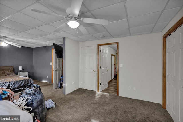 unfurnished bedroom featuring dark carpet, a paneled ceiling, and ceiling fan