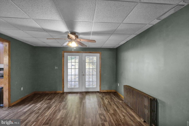 unfurnished room with hardwood / wood-style floors, a drop ceiling, french doors, and ceiling fan