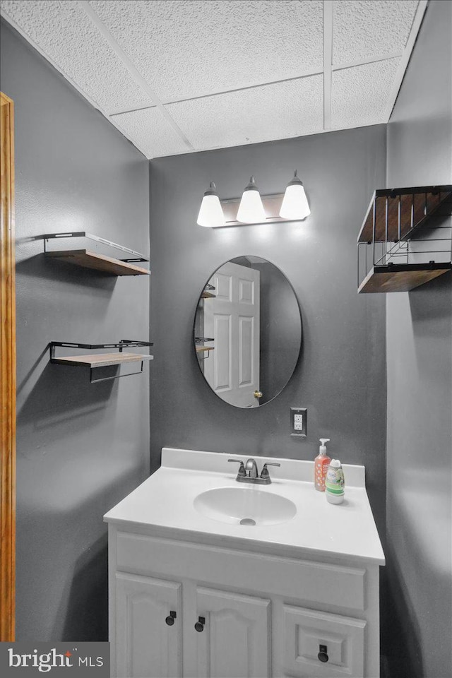 bathroom featuring vanity and a drop ceiling