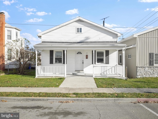 bungalow-style house featuring covered porch and a front lawn