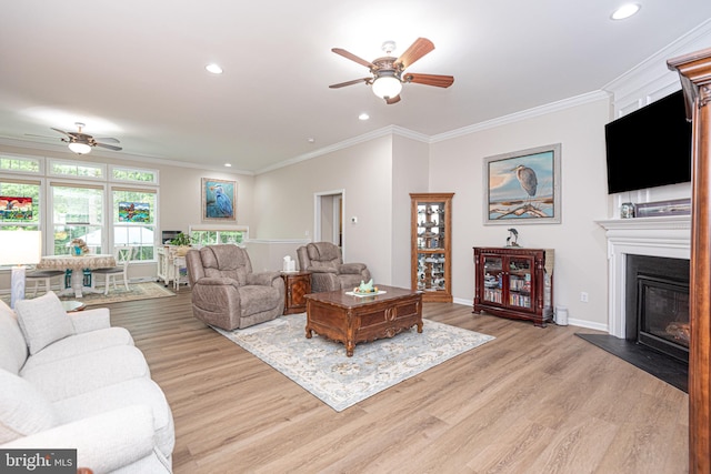 living room with light wood-type flooring, ceiling fan, and crown molding