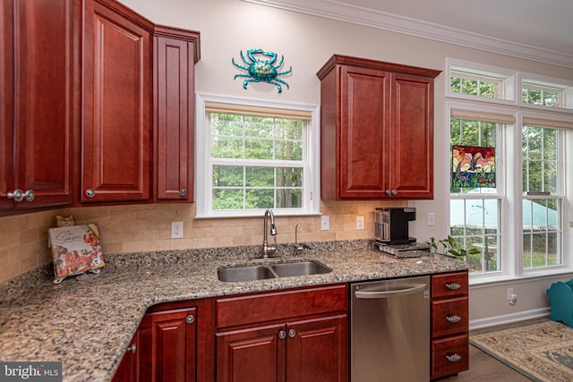 kitchen with stainless steel dishwasher, a wealth of natural light, sink, and ornamental molding