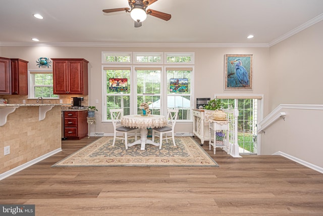 dining space with ornamental molding, dark wood-type flooring, and ceiling fan