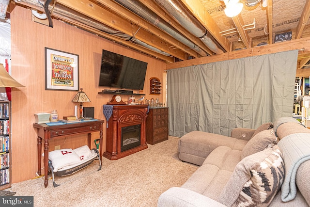 carpeted living room featuring wooden walls