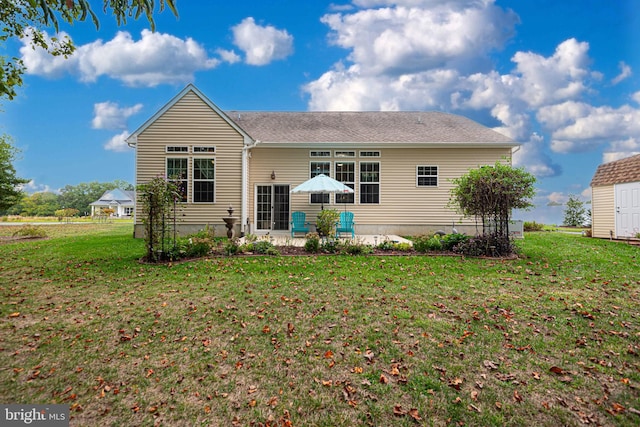 rear view of property featuring a shed, a lawn, and a patio