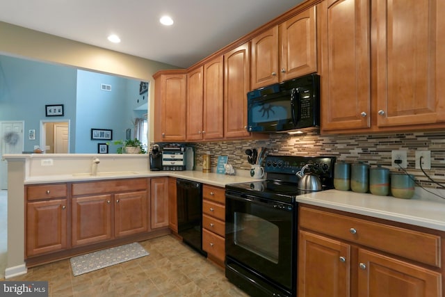 kitchen featuring sink, kitchen peninsula, tasteful backsplash, and black appliances