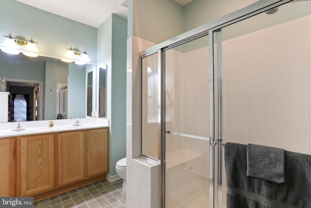 bathroom with tile patterned floors, an enclosed shower, vanity, and toilet