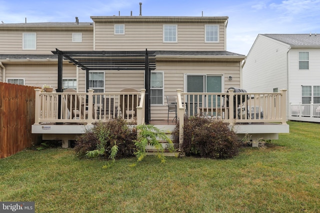 back of house featuring a deck, a pergola, and a lawn