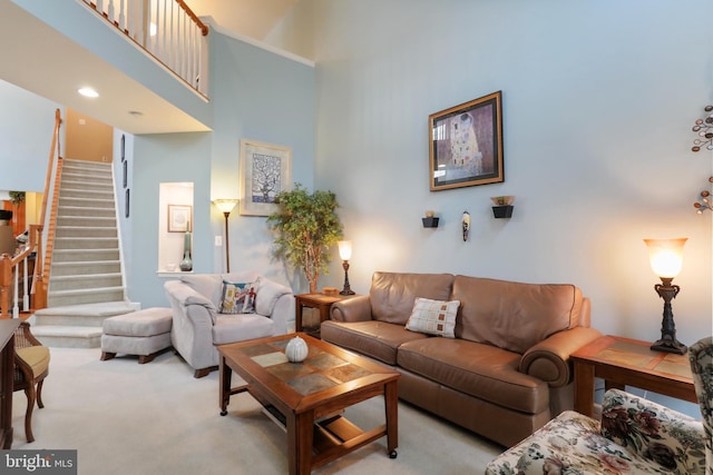 carpeted living room featuring a towering ceiling