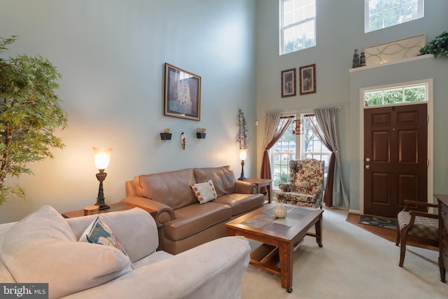 living room with light colored carpet and a towering ceiling