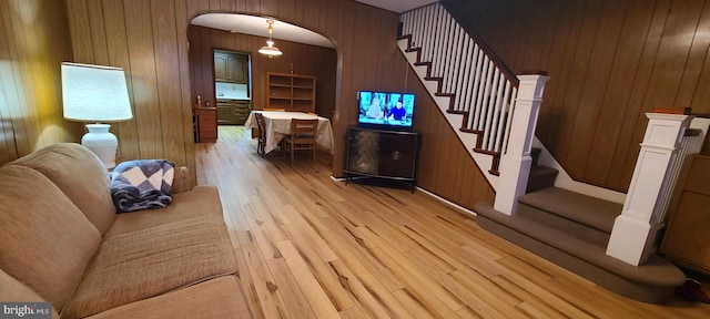 living room featuring light hardwood / wood-style floors and wooden walls