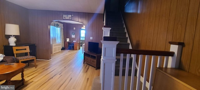 staircase featuring wood walls and hardwood / wood-style floors