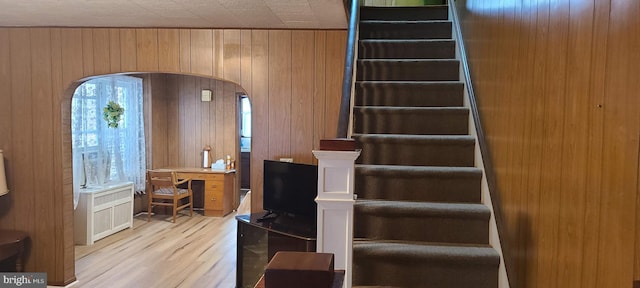 staircase featuring hardwood / wood-style flooring and wooden walls