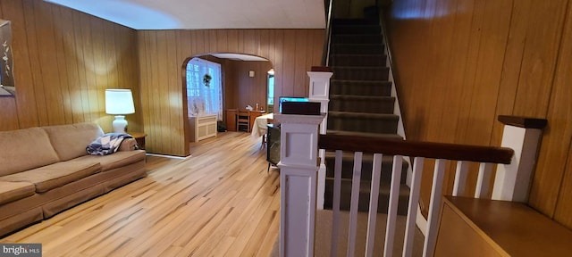 living room featuring light hardwood / wood-style flooring and wooden walls