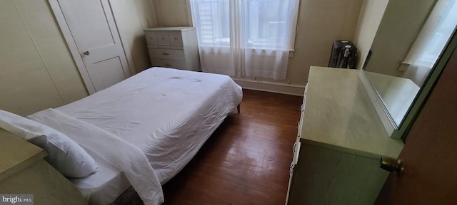 bedroom featuring radiator heating unit, a closet, and dark hardwood / wood-style flooring