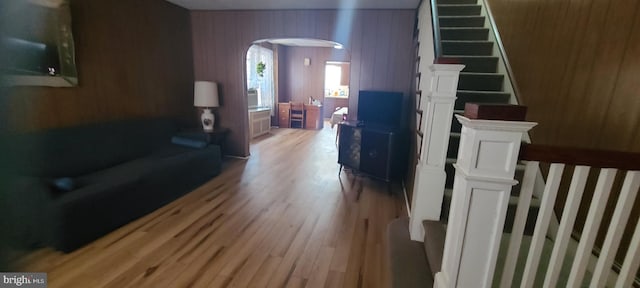 living room with wooden walls and light hardwood / wood-style floors