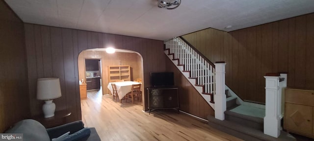 stairway featuring hardwood / wood-style floors and wooden walls