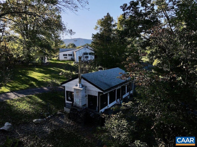 exterior space with a yard, a mountain view, and a sunroom