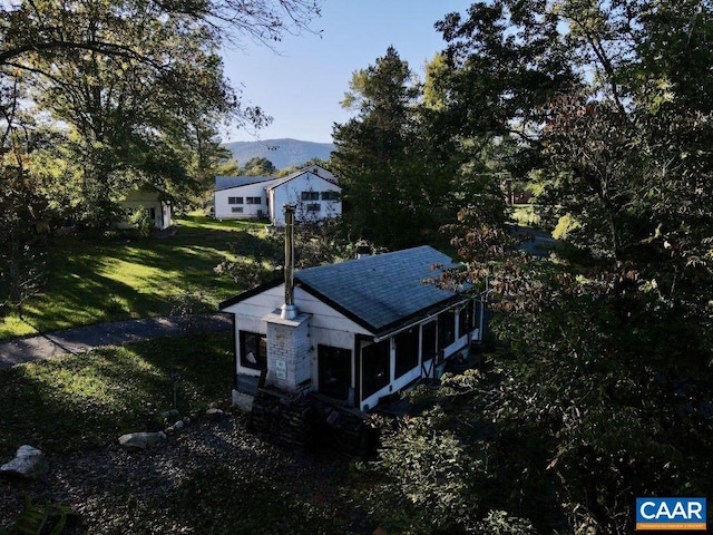 exterior space featuring a mountain view and a lawn