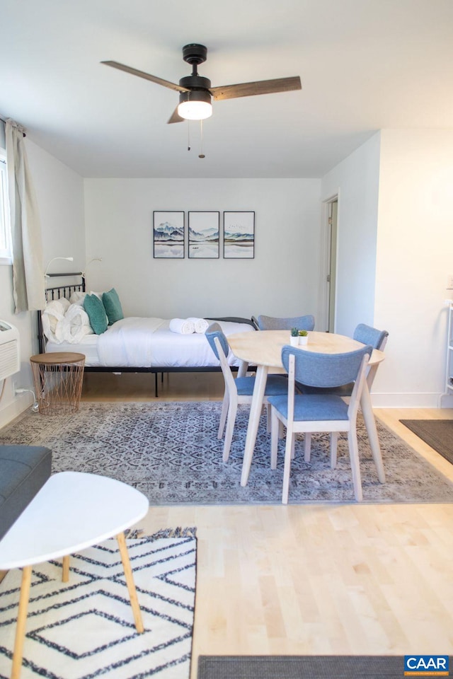 dining space featuring wood-type flooring and ceiling fan