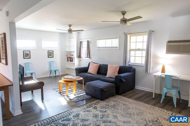 living room with a wall unit AC, dark hardwood / wood-style floors, and ceiling fan