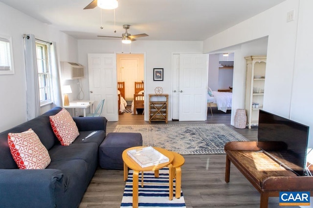 living room with ceiling fan, an AC wall unit, and dark hardwood / wood-style flooring