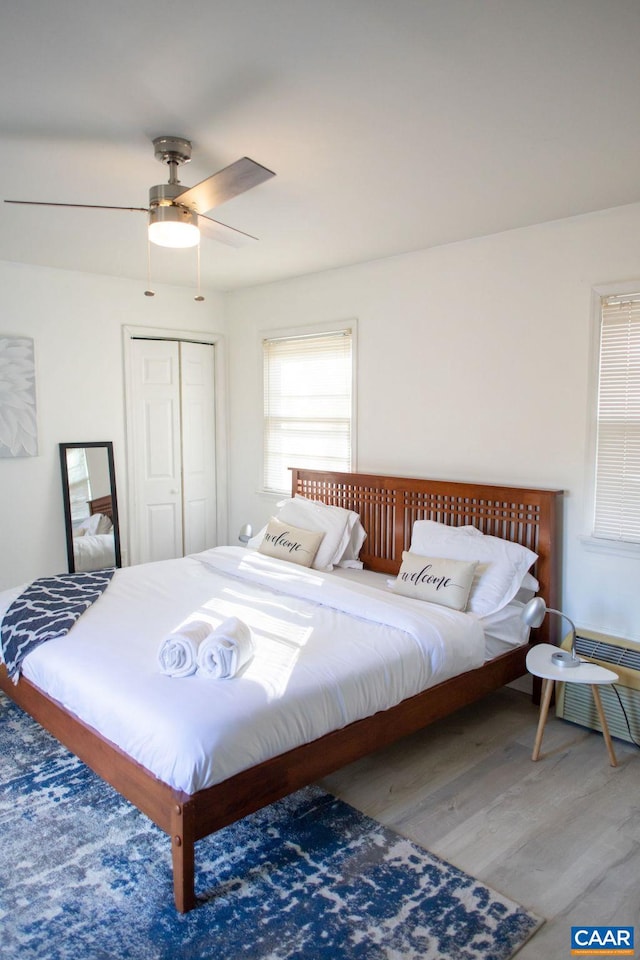 bedroom with a closet, hardwood / wood-style floors, and ceiling fan