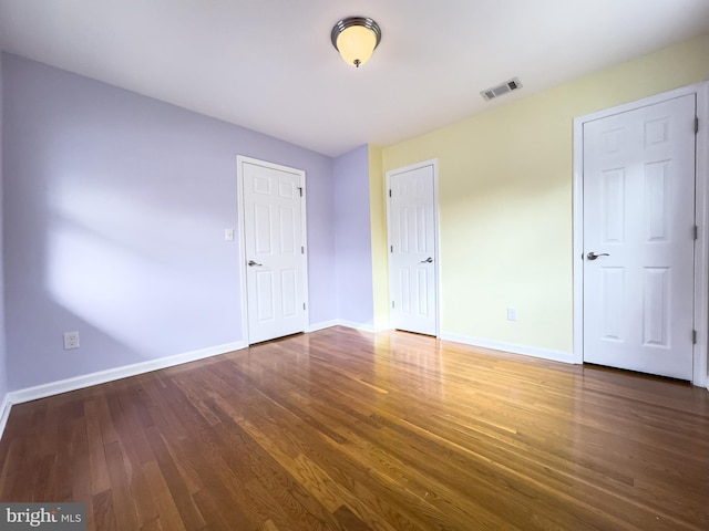 unfurnished bedroom with dark hardwood / wood-style floors