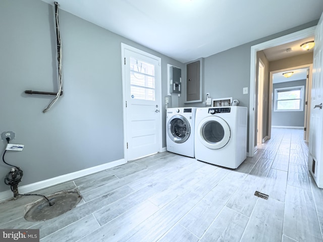 laundry room with washer and dryer, electric panel, and light hardwood / wood-style flooring